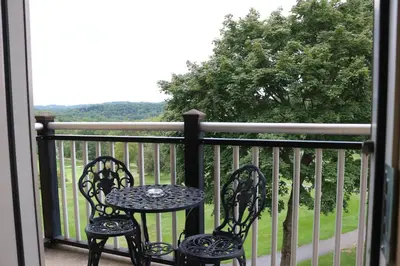 two chairs and a table on a balcony at The Lodge at Woodstone Country Club in Danielsville