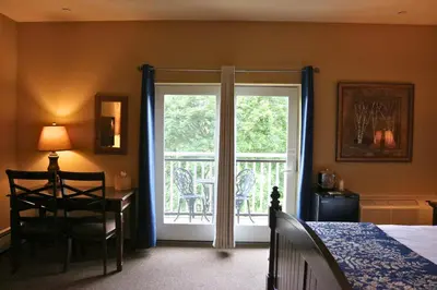 a bedroom with a bed and a sliding glass door at The Lodge at Woodstone Country Club in Danielsville