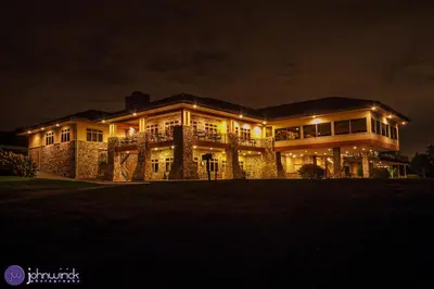 a large house lit up at night with lights at The Lodge at Woodstone Country Club in Danielsville