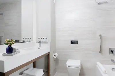 a bathroom with a sink and a toilet and a mirror at Courtyard New York Manhattan/Midtown West in New York