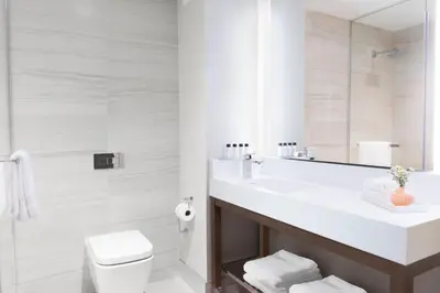a bathroom with a sink and a toilet and a mirror at Courtyard New York Manhattan/Midtown West in New York