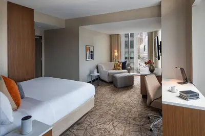a hotel room with a bed and a living room at Courtyard New York Manhattan/Midtown West in New York