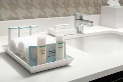 a bathroom counter with a sink with products on it at Home2 Suites By Hilton Edison in Edison