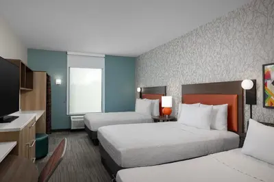 a hotel room with two beds and a television at Home2 Suites By Hilton Edison in Edison