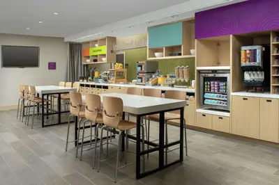 a restaurant with tables and chairs and a drink bar at Home2 Suites By Hilton Edison in Edison