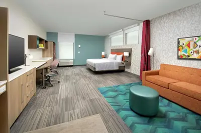 a hotel room with a bed and a couch at Home2 Suites By Hilton Edison in Edison