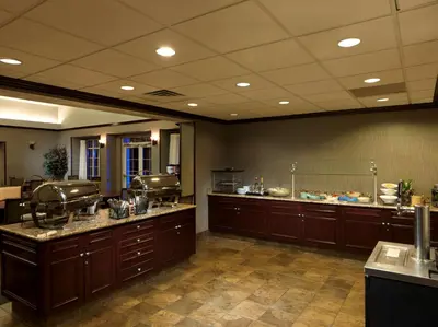 a large kitchen with wooden cabinets and a counter at Homewood Suites by Hilton Dover - Rockaway in Dover