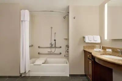 a bathroom with a tub and a sink at Homewood Suites by Hilton Dover - Rockaway in Dover