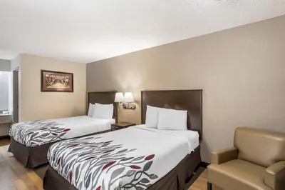 a hotel room with two beds and a chair at Red Roof Inn Danville, PA in Danville
