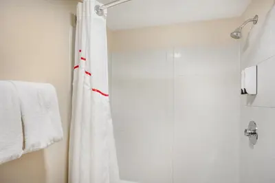 a bathroom with a shower with a white shower curtain at Red Roof Inn Danville, PA in Danville