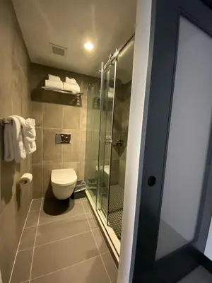 a bathroom with a toilet and a glass shower at Wingate by Wyndham New York Midtown South/5th Ave in New York