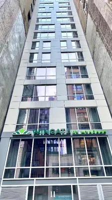 a tall building with a sign on the side of it at Wingate by Wyndham New York Midtown South/5th Ave in New York