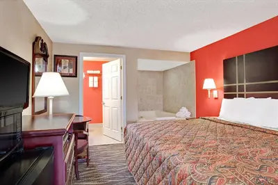 a hotel room with a bed and a flat screen tv at Days Inn by Wyndham Ridgefield NJ in Ridgefield