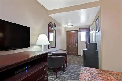 a hotel room with a bed and a flat screen tv at Days Inn by Wyndham Ridgefield NJ in Ridgefield