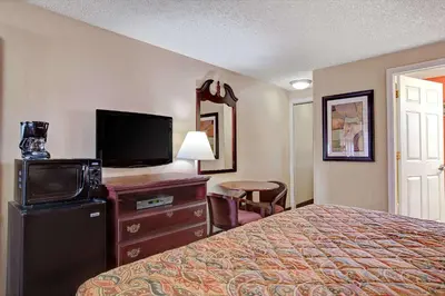 a hotel room with a bed and a flat screen tv at Days Inn by Wyndham Ridgefield NJ in Ridgefield