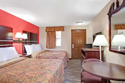 a hotel room with two beds and a table at Days Inn by Wyndham Ridgefield NJ in Ridgefield