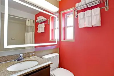 a red bathroom with a toilet and a sink at Days Inn by Wyndham Ridgefield NJ in Ridgefield