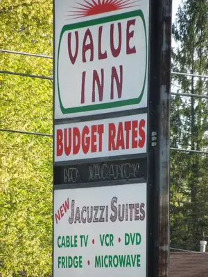 a sign for a village inn andbucket rates at Value Inn East Stroudsburg in Marshalls Creek