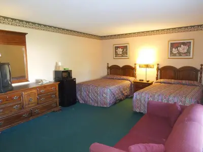a hotel room with two beds and a couch at Value Inn East Stroudsburg in Marshalls Creek