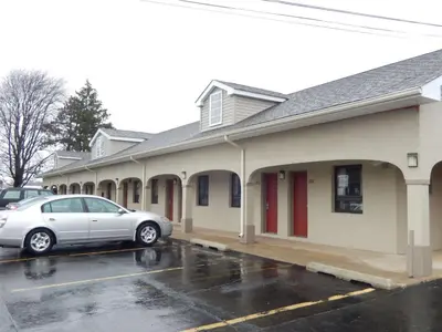 a car parked in a parking lot in front of a building at Scottish Inns and Suites- Bordentown, NJ in Bordentown