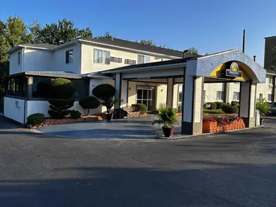 a building with a parking lot in front of it at Days Inn by Wyndham Runnemede Philadelphia Area in Runnemede
