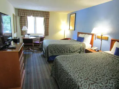 a hotel room with two beds and a desk at Days Inn by Wyndham Runnemede Philadelphia Area in Runnemede