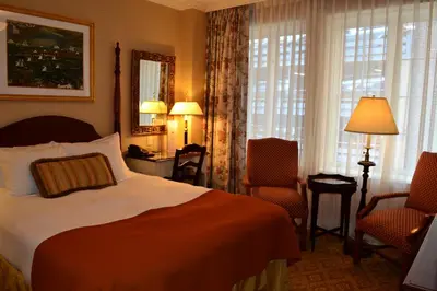 a hotel room with a bed and two chairs at The Wall Street Inn in New York