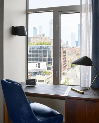 a desk with a chair and a lamp and a window at Gansevoort Meatpacking in New York