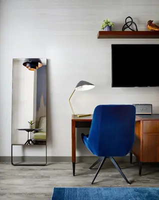 a blue chair sitting next to a desk with a television at Gansevoort Meatpacking in New York
