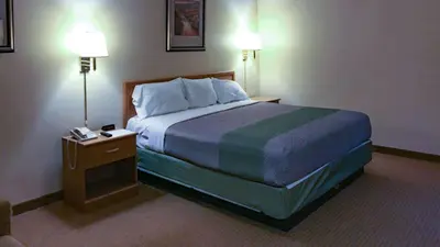 a hotel room with a large bed and two lamps at Motel 6-Bloomsburg, PA in Bloomsburg