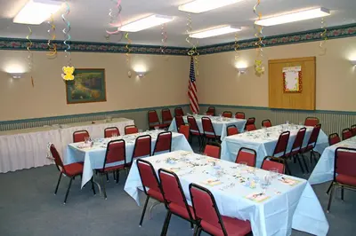 a banquet room with tables and chairs with white tablecloths at Motel 6-Bloomsburg, PA in Bloomsburg