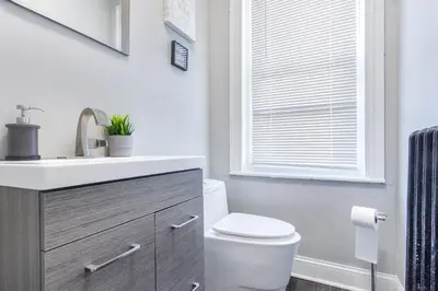 a bathroom with a toilet and a sink and a window at Philly Coed Dorm!! 15 Min Train to Center City!! in Philadelphia