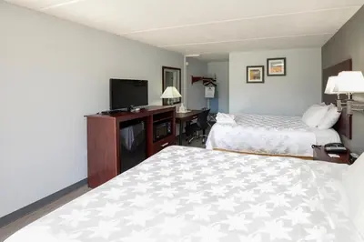 a hotel room with two beds and a flat screen tv at Americas Best Value Inn at Central Valley-Woodbury in Central Valley
