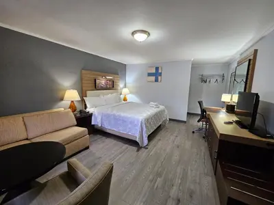 a hotel room with a bed and a couch at Americas Best Value Inn at Central Valley-Woodbury in Central Valley