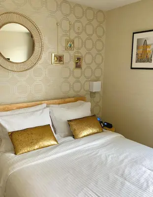 a bedroom with a large white bed with a mirror at Hotel Mimosa in New York