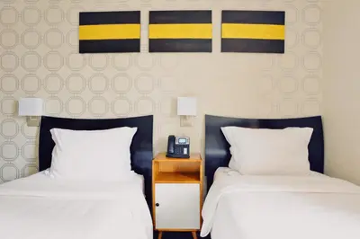 a hotel room with two beds and a telephone at Hotel Mimosa in New York