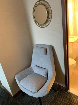 a gray chair in a corner with a mirror at Hotel Mimosa in New York