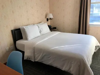 a hotel room with a large bed with white sheets at Hotel Mimosa in New York