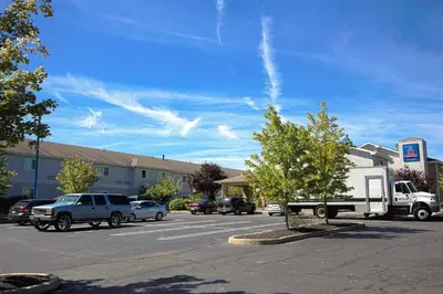 a parking lot with cars parked in front of a building at Motel 6-East Brunswick, NJ in East Brunswick