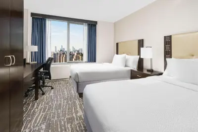 a hotel room with two beds and a window at Fairfield Inn & Suites by Marriott New York Midtown Manhattan/Penn Station in New York