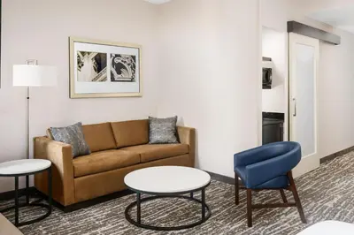 a living room with a couch and a table and chairs at Fairfield Inn & Suites by Marriott New York Midtown Manhattan/Penn Station in New York