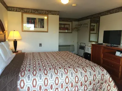 a hotel room with a bed and a flat screen tv at Americas Best Value Inn - Palmyra/Hershey in Palmyra