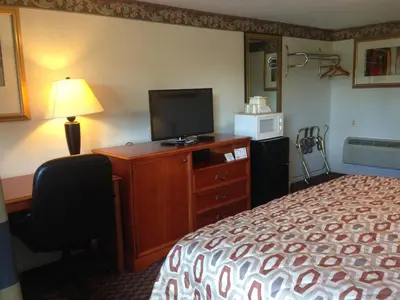 a hotel room with a bed and a flat screen tv at Americas Best Value Inn - Palmyra/Hershey in Palmyra