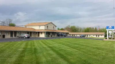 a large green field in front of a parking lot at Americas Best Value Inn - Palmyra/Hershey in Palmyra