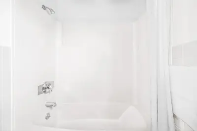 a white bathroom with a sink and a shower at Knights Inn Pine Grove in Pine Grove