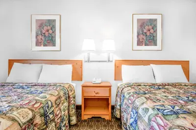 a hotel room with two beds and a night stand at Knights Inn Pine Grove in Pine Grove