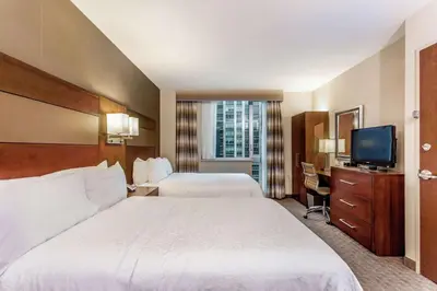 a hotel room with two beds and a flat screen tv at Hampton Inn Manhattan Grand Central in New York