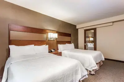 two beds in a hotel room with white sheets at Hampton Inn Manhattan Grand Central in New York