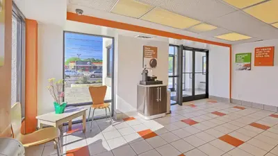 a lobby with a waiting room with a table and chairs at Motel 6-Maple Shade Township, NJ - Philadelphia - Mt Laurel in Maple Shade