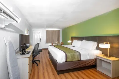 a bedroom with a bed and a desk with a television at American Inn in Carlisle